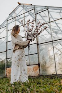 Kaboompics - A beautiful tall woman holds cotton branches