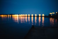 Blurred city lights reflected in the water at night