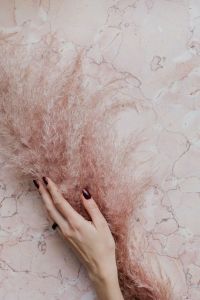Kaboompics - Pink marble background, female hand and pampas grass