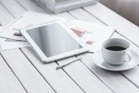 Coffee on table with a tablet