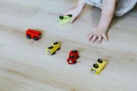 Child playing with wooden cars