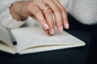 Woman holding a ring over a notebook