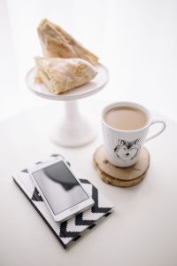Black-and-white notebook and a white smarphone with various items
