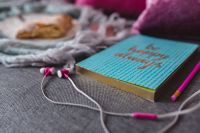Blue notebook with headphones and a sweet bun