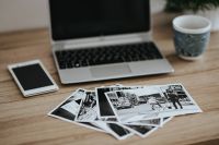 Black-and-white photos with a silver laptop, a smartphone and a mug