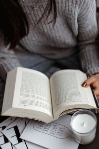 A woman in a sweater reads a book