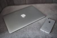 Silver laptop and an iPhone on a grey sofa