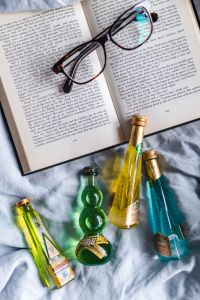 Group of colorful little bottles with liqueurs & book with glasses