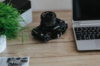 Black-and-white photos with a silver laptop and a camera