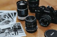 Black Canon camera with lenses and black-and-white photos