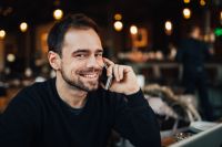 Young smiling man using mobile phone