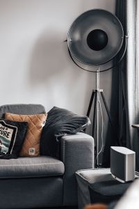 Grey couch, pillows, floor lamp