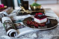 Cheesecake and magazine on a marble table
