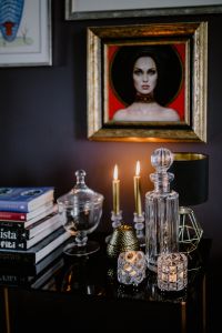 Decanter, candles, and a painting on the wall