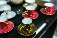 Red and golden teacups with saucers
