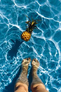 Baby Pineapple & Women's Legs in a Swimming Pool