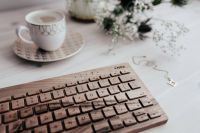 Wooden keyboard, coffee and golden jewellery