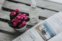 Little pink flowers with a bottle of water and a magazine