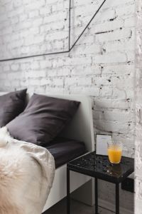 White brick wall, bed and marble bedside table