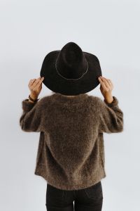 Kaboompics - A woman in a brown sweater with a black hat on her head