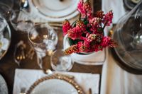 Table decorations with golden motifs and red flowers