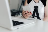 Businesswoman uses her iPhone mobile at her desk