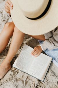 Kaboompics - A woman reads on the beach in the summer