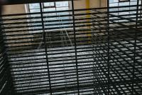 A view through the grating in an abandoned building hall