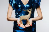 Kaboompics - Woman in Blue Dress Holds Gold Reindeer