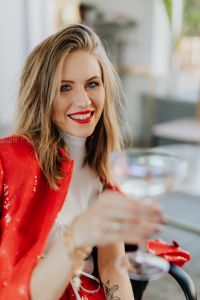 Kaboompics - Woman in a red jacket holds a glass