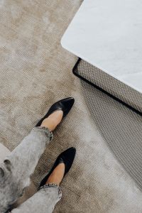 Woman wearing grey jeans & black leather high heels
