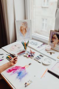 A woman paints with watercolors