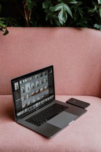 MacBook Pro laptop & iPhone X mobile on a pink sofa