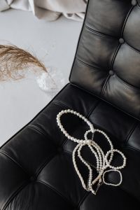 Kaboompics - Pearl necklaces - jewelry - black leather chair - Ludwig Mies van der Rohe - Lounge chair - Barcelona chair