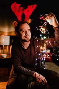A handsome young man with Christmas tree lamps