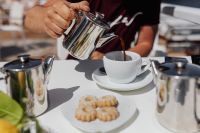 Kaboompics - Pouring coffee into a cup. Silver kettles, Italian cookies.