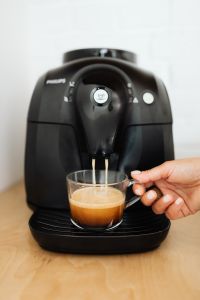 The woman makes coffee with the machine