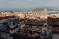 Panorama of the city Naples and the volcano Vesuvius. Old houses at sunset
