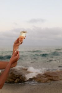 Kaboompics - Muted Tones & Golden Hour Hues - Women Celebrating by the Sea with Champagne