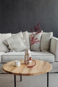 Wooden coffee table - rug - living room - candle - vase - linen couch - pillows