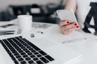 Businesswoman uses her iPhone mobile at her desk