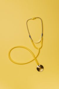 Kaboompics - Yellow stethoscope and pills on yellow background