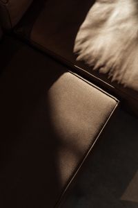 A moody close-up of a leather sofa with natural light casting soft shadows emphasizing the texture of the material