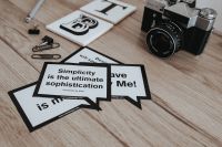 Kaboompics - Little cards with inspirational quotes and a black camera