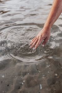 Man hand touching sea surface