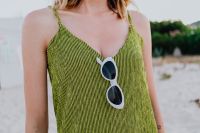 Kaboompics - A woman in a green dress on the beach with white sunglasses