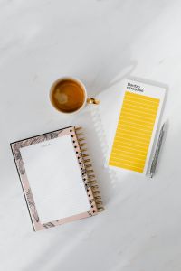 Kaboompics - Top view of a marble desk with coffee, notebooks and pen