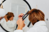Kaboompics - Woman Straightening Healthy Hair With Flat Iron - Hair Straightener