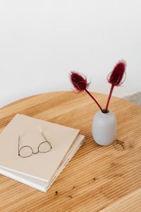 Wooden table - books - glasses - vase with dried flowers