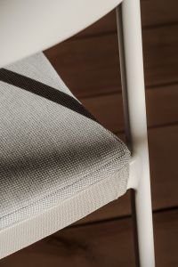 Soft light casting shadows on a curved modern dining chair